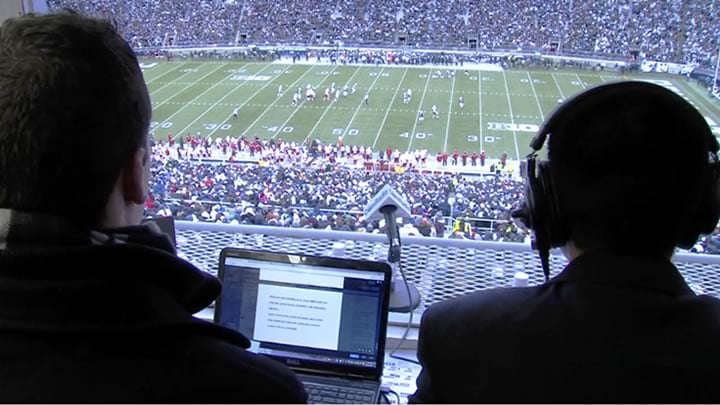Students sit in the press box doing live radio coverage of a Penn State football game